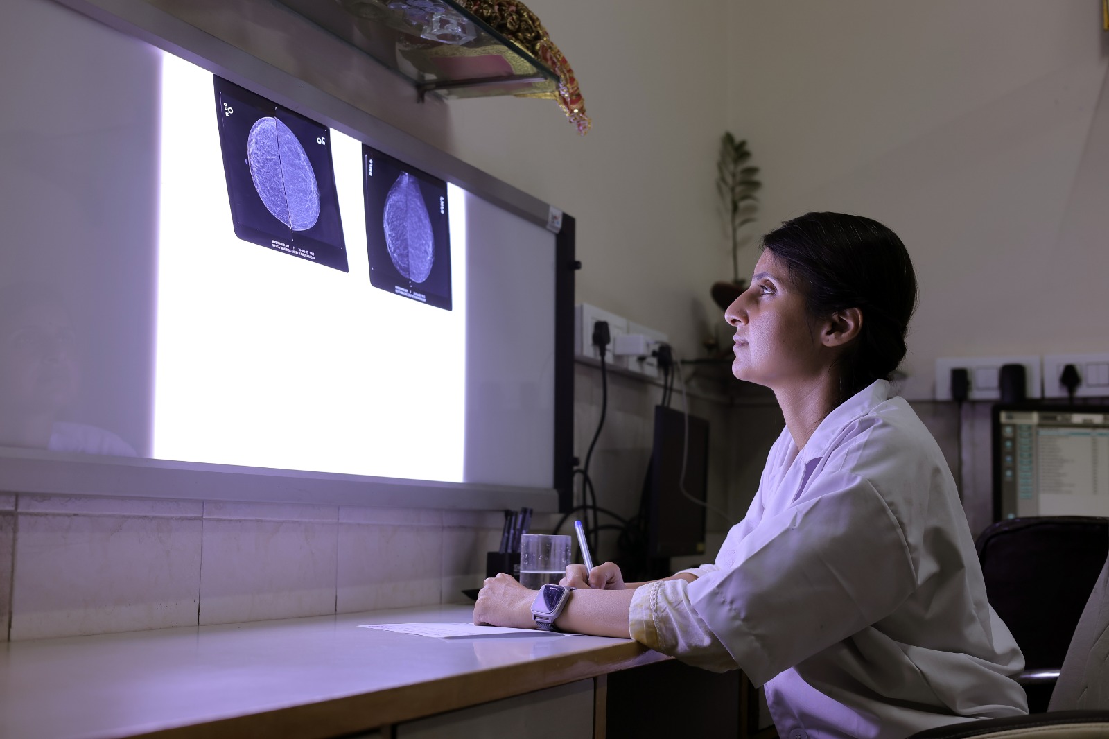 Two medical technicians reviewing diagnostic images on computers.