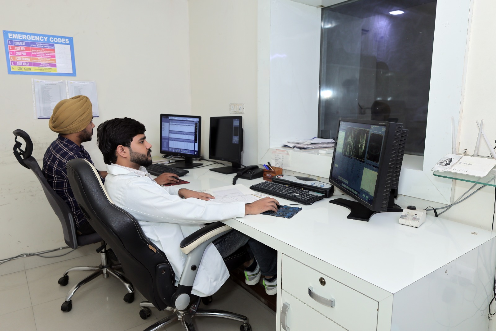 Doctor at his desk reviewing a detailed spinal scan.