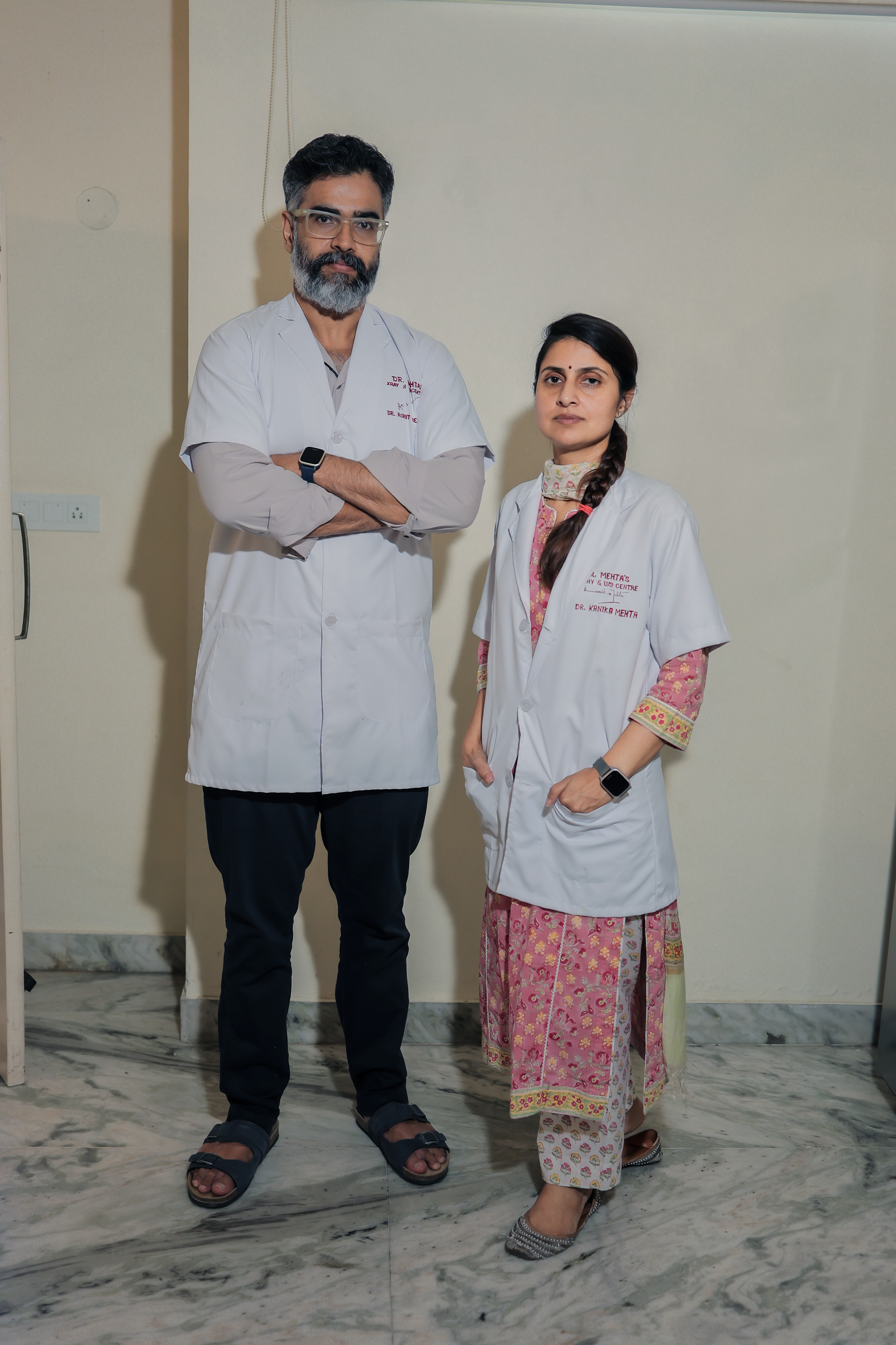 Technician operating the controls of a GE MRI machine with a patient inside.