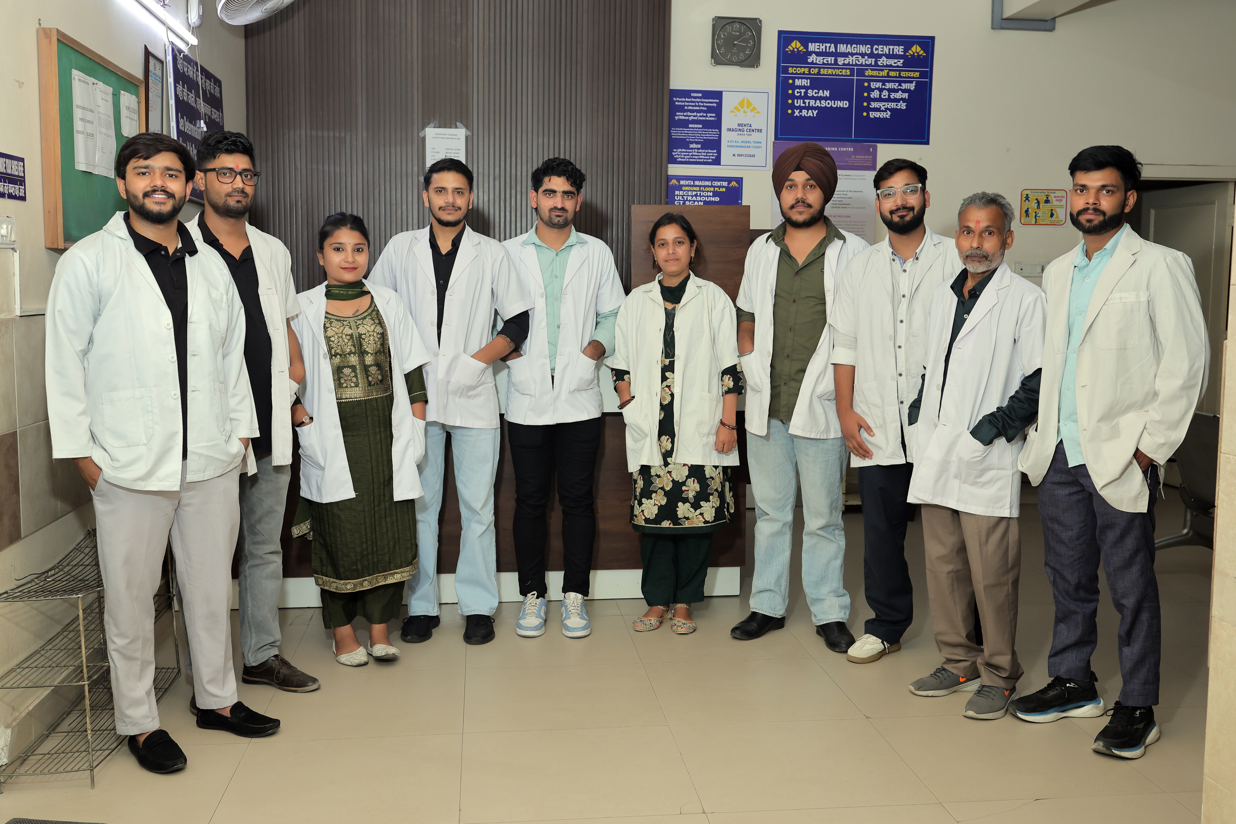 Technician operating the controls of a GE MRI machine with a patient inside.